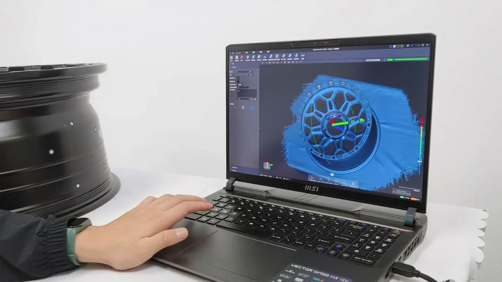 Taranmış 3D modelin laptop ekranında gösterimi ve taranmış cismin bir kısmı.